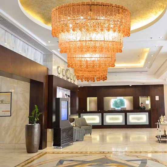Lampadario moderno in cristallo dorato a strati nella hall dell'hotel moderno. Lampadario contemporaneo a sospensione in cristallo dorato del Nord Europa
